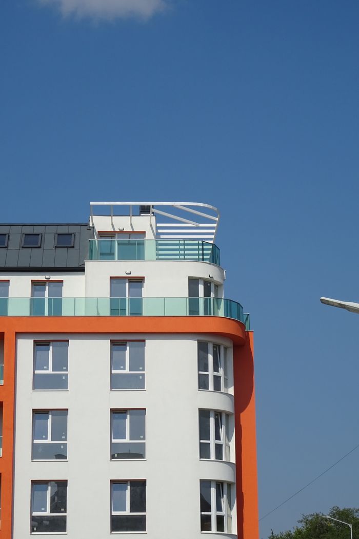 services-01 Contemporary apartment building against a clear blue sky. Ideal for urban architecture concepts.